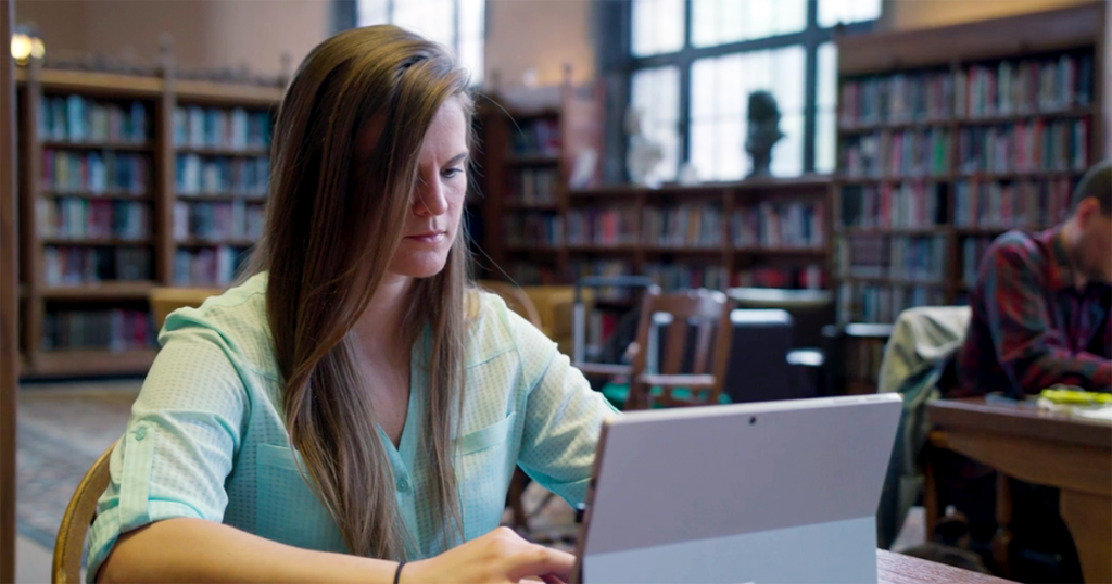 Woman working on laptop in library